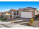 Tan colored house with a large garage and well-manicured lawn at 10499 Skye Paseo Ave, Las Vegas, NV 89166