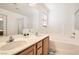 Bathroom with a double sink vanity, large mirror, soaking tub, and a separate glass-enclosed shower at 11276 Accademia Ct, Las Vegas, NV 89141