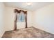 Bedroom with neutral carpet, a window with decorative curtains, and blank walls awaiting personal touches at 11276 Accademia Ct, Las Vegas, NV 89141