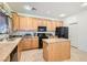 Kitchen with island, wood cabinets, and black appliances at 11276 Accademia Ct, Las Vegas, NV 89141