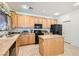 Well-lit kitchen featuring a central island, pantry and traditional cabinetry at 11276 Accademia Ct, Las Vegas, NV 89141