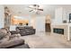 Open-concept living room with a fireplace and view of the kitchen and staircase at 11276 Accademia Ct, Las Vegas, NV 89141