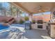 Backyard with complete outdoor kitchen and BBQ area with covered patio next to the pool at 11276 Accademia Ct, Las Vegas, NV 89141