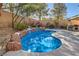 The private backyard features a freeform pool and spa with rock accents, next to an outdoor kitchen at 11276 Accademia Ct, Las Vegas, NV 89141