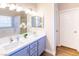 Bathroom with double vanity, marble countertop, and light blue cabinets at 114 Appian Way, Henderson, NV 89002