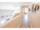 Upstairs hallway with hardwood floors and modern wall art at 114 Appian Way, Henderson, NV 89002