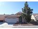 Single-story house with a two-car garage and landscaped front yard at 1235 Pagentry Dr, North Las Vegas, NV 89031