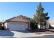 Single-story house with a two-car garage and mature tree in front at 1235 Pagentry Dr, North Las Vegas, NV 89031