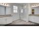 Bright bathroom with double vanity, white cabinets, framed mirrors, walk-in shower, and a window providing natural light at 129 Castanet Ln # Lot 190, Henderson, NV 89015