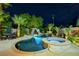 Stunning nighttime view of a backyard pool, spa, and landscape lighting at 156 Ozuna Ct, Las Vegas, NV 89183