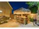 Outdoor tiki bar with seating and string lights at 156 Ozuna Ct, Las Vegas, NV 89183