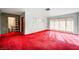 Living room with red carpet, wood paneling, and adjacent door at 2105 Berkley Ave, Las Vegas, NV 89101