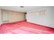 Bright living room featuring red carpet and wood-paneled wall at 2105 Berkley Ave, Las Vegas, NV 89101