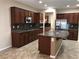 Modern kitchen with granite countertops, stainless steel appliances, and dark wood cabinets at 2416 Weaverville Dr, Henderson, NV 89044