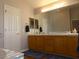 Double sink bathroom with wood cabinets and a large mirror at 2525 Huber Heights Dr, Las Vegas, NV 89128