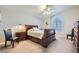 Spacious bedroom with wooden sleigh bed, ceiling fan, and arched window at 2525 Huber Heights Dr, Las Vegas, NV 89128