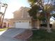 Two-story house with a white garage door and landscaped yard at 2525 Huber Heights Dr, Las Vegas, NV 89128