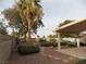 Landscaped backyard with patio cover, stone pathway, and mature plants at 2662 Churchill Cir, Henderson, NV 89074