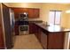 Modern kitchen with stainless steel appliances and wood cabinets at 2662 Churchill Cir, Henderson, NV 89074