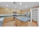 Modern kitchen with island, wood cabinets, and stainless steel appliances at 295 Blackstone River Ave, Las Vegas, NV 89148