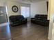 Living room featuring two black reclining sofas and wood-look flooring at 307 E Van Wagenen St, Henderson, NV 89015