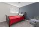 Bright bedroom featuring a red bed and a gray armchair at 4027 Boratko St, Las Vegas, NV 89115