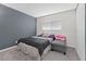 Cozy bedroom with a dark-colored bed and a gray ottoman at 4027 Boratko St, Las Vegas, NV 89115