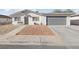 Ranch style home with gray garage door and landscaped yard at 4027 Boratko St, Las Vegas, NV 89115