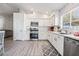 Modern kitchen with white cabinets, stainless steel appliances, and gray flooring at 5370 Cholla Cactus Ave, Las Vegas, NV 89141