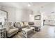 Bright and airy living room with gray sectional sofa and whitewashed brick accent wall at 5370 Cholla Cactus Ave, Las Vegas, NV 89141