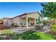 Covered patio, grassy area, firepit, and dining furniture at 5805 Vibrant Violet Ct, Las Vegas, NV 89130