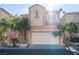 Tan two-story house with attached garage, landscaping, and driveway at 6641 Hurkling Stone Ave, Las Vegas, NV 89139