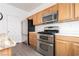 Modern kitchen with stainless steel appliances and oak cabinets at 6641 Hurkling Stone Ave, Las Vegas, NV 89139