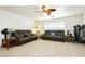 Relaxing game room with leather couches, a ceiling fan, and natural light at 7317 Wild Roar Ave, Las Vegas, NV 89129