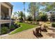 Landscaped backyard with grassy area and two wooden chairs at 7880 Dana Point Ct, Las Vegas, NV 89117