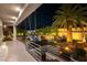 Gorgeous outdoor patio with built-in kitchen, tropical landscaping, nearby waterfall, and comfortable seating at 7880 Dana Point Ct, Las Vegas, NV 89117