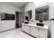 Elegant bathroom featuring a double vanity, marble countertops, black sinks, and modern fixtures, complemented by a wall-mounted TV at 7880 Dana Point Ct, Las Vegas, NV 89117