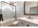 A sleek bathroom boasts a shower-over-tub with glass screen, decorative tiled wall and modern vanity at 7880 Dana Point Ct, Las Vegas, NV 89117