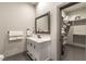 Modern bathroom featuring a marble countertop vanity, mirror and a glimpse into an organized closet space at 7880 Dana Point Ct, Las Vegas, NV 89117