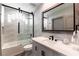 Modern bathroom with a marble vanity, black fixtures, and a sleek glass-enclosed shower at 7880 Dana Point Ct, Las Vegas, NV 89117