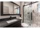 Modern bathroom with marble-tiled walk-in shower, dark vanity, and sleek fixtures at 7880 Dana Point Ct, Las Vegas, NV 89117