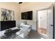 A modern home office featuring a sleek desk, large TV, and a door to an adjoining bathroom at 7880 Dana Point Ct, Las Vegas, NV 89117