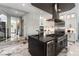 Kitchen features a dark island with stainless appliances, white cabinets, and marble floors at 7880 Dana Point Ct, Las Vegas, NV 89117