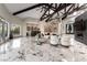 Spacious living room boasts vaulted beamed ceilings, stone fireplace, bar, and beautiful marble floors at 7880 Dana Point Ct, Las Vegas, NV 89117