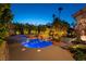 Backyard pool and jacuzzi illuminated at night with palm trees at 7880 Dana Point Ct, Las Vegas, NV 89117