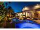 Backyard pool and jacuzzi illuminated at night with palm trees at 7880 Dana Point Ct, Las Vegas, NV 89117