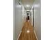 Long hallway with light wood flooring and multiple doors leading to bedrooms and other rooms at 8116 Sedona Sunset Dr, Las Vegas, NV 89128