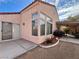 Rear house exterior showcasing a covered patio, large windows, and a desert landscape at 8116 Sedona Sunset Dr, Las Vegas, NV 89128