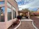 House exterior showcasing a covered patio, large windows, and a desert landscape at 8116 Sedona Sunset Dr, Las Vegas, NV 89128