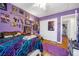 Bright bedroom with purple walls and a colorful bedspread at 8529 Copper Knoll Ave, Las Vegas, NV 89129